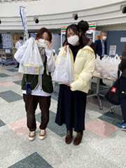 写真：食品セットの入った袋を持つ学生たち