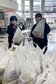 写真：食料品が詰まった袋を持つ学生たち