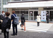 写真:「入学式」と書かれたタテカンと写真を取る学生たち