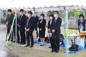 写真：雨の中テントの下に並ぶ教員たち