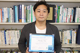 写真：表彰状をもつ斉藤雅茂教授