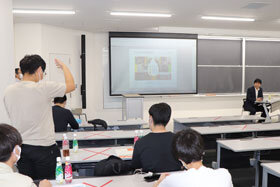 写真：手をあげて質問をする学生