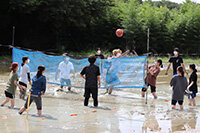 写真：泥んこになりながらバレーボールを楽しむ様子