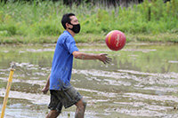 写真：泥んこになりながらバレーボールを楽しむ男性