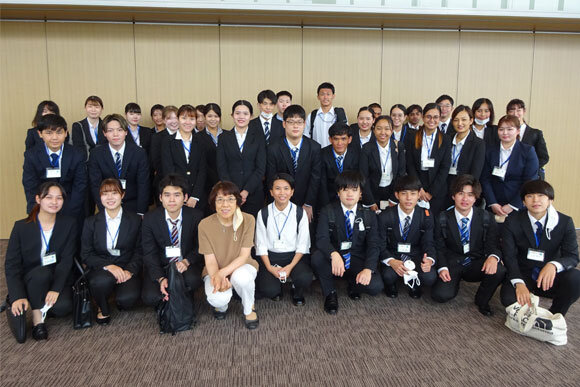 写真:スーツ姿で笑顔の学生たちの集合写真
