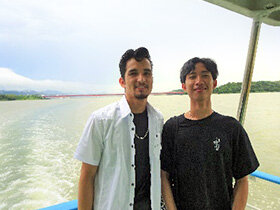 写真：船上で記念撮影をする男子学生2人