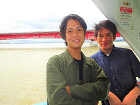 写真：船上で記念撮影をする男子学生2人
