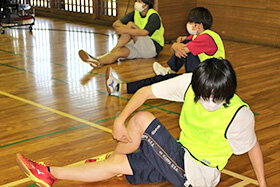 写真：準備運動をする学生たち