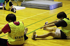 写真：準備運動をする学生たち