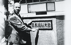 中部社会事業短期大学の看板を日本福祉大学の看板にかけかえる鈴木修学先生