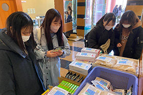 写真:テーブルの物品を眺める学生たち