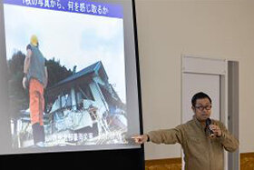 写真：被災地の写真とともに講演する様子