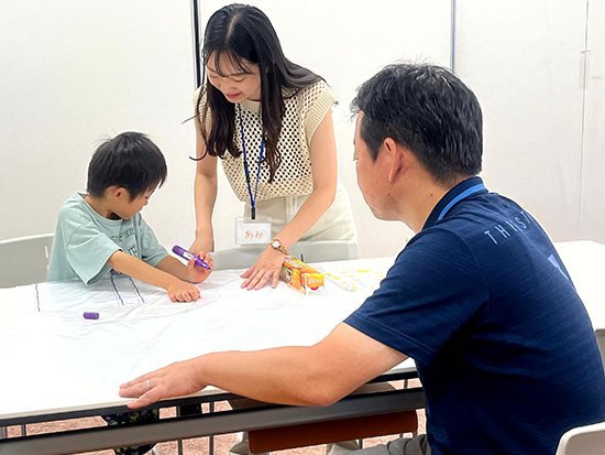 参加された子どもとポンチョを作成している学生