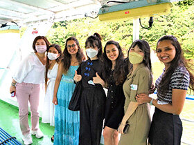 写真：船上で楽しそうに記念撮影をする留学生と学生たち