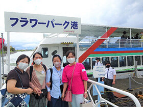 写真:フラワーパーク港の前で記念撮影をする学生たち